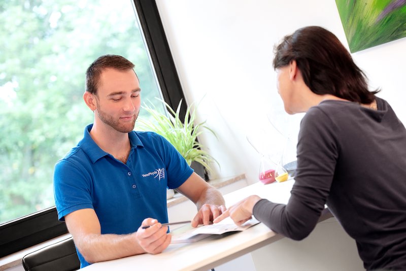 Gespräch am Tisch in der Physiotherapiepraxis.