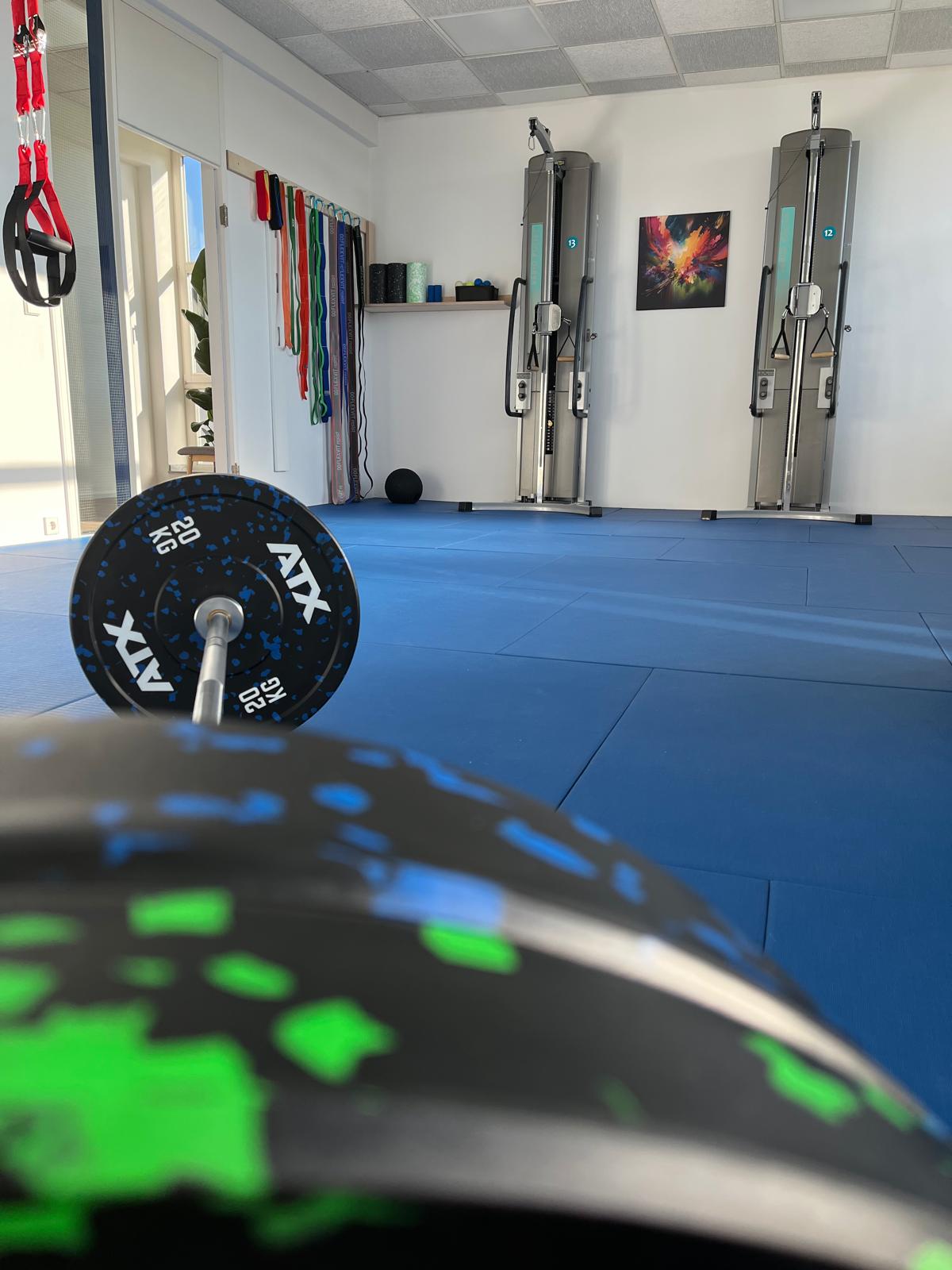 Trainingsraum mit Langhantel, Widerstandsbändern und Seilzuggeräten